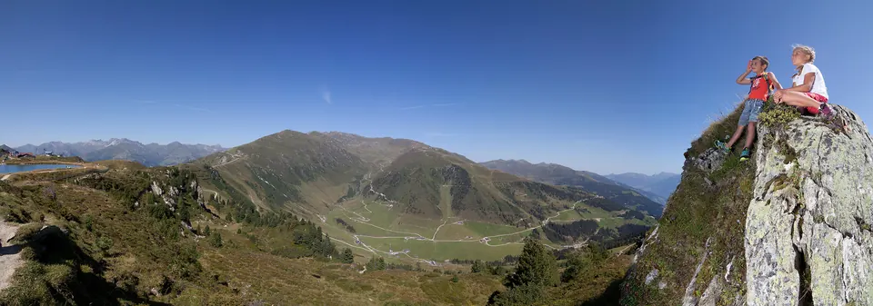 Bergpanorama mit Wanderern auf einem Felsen