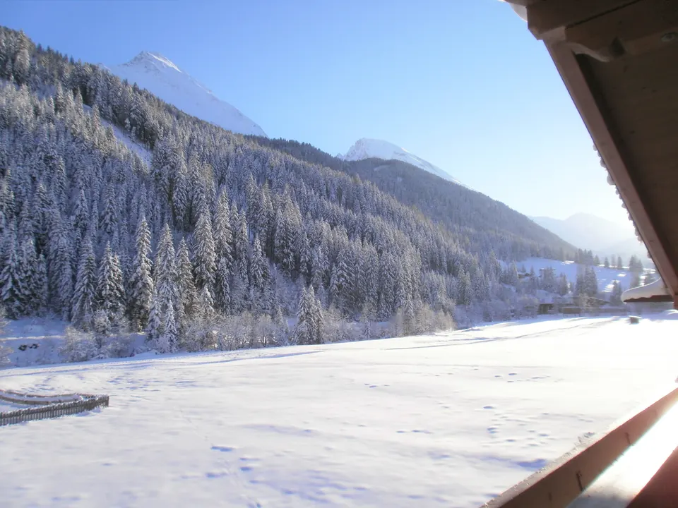 Blick vom Balkon auf das verschneite Tal